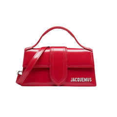 Jacquemus Le Bambino Bag in vibrant red, featuring a sleek, structured design and a top handle. The handbag is made from smooth leather, showcasing minimalist aesthetics and a bold color, perfect for a stylish women's accessory."