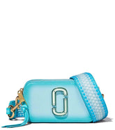 Marc Jacobs Light Blue Fluoro Edge Small Crossbody Bag for women, featuring a soft light blue color with vibrant fluoro edge detailing. The bag includes an adjustable strap and a compact design, making it a stylish and functional accessory for everyday use.