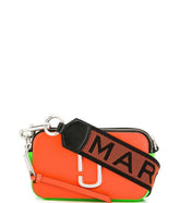 Marc Jacobs Orange Snapshot Small Crossbody Bag for women, featuring a vibrant orange color and a compact design. The bag includes an adjustable strap and the signature logo, making it a stylish and eye-catching accessory for everyday use.