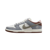 Nike SB Dunk Low Yuto Horigome features a white leather base with grey nubuck leather overlays, while Chocolate Brown suede panels appear on the collar and pink leather is seen on the heel tab with 'Nike' branding.