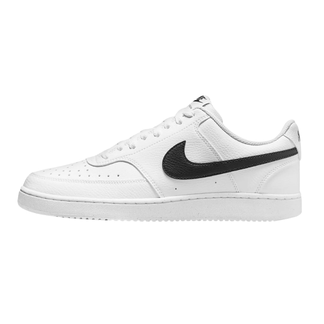  Nike Court Vision Low Next Nature sneakers in white and black, designed for women. The shoes feature a clean white leather upper with black accents and a classic low-top silhouette, highlighted by eco-friendly materials. Displayed against a neutral background to emphasize their sleek and modern style.



