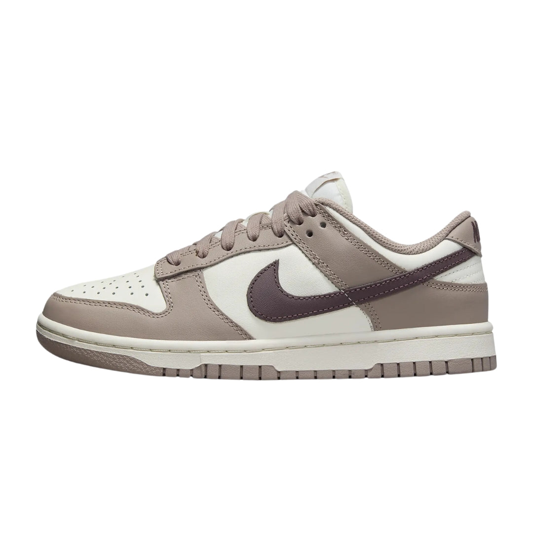 Nike Dunk Low "Diffused Taupe" sneakers featuring a soft taupe leather upper with darker brown accents. The classic low-top design includes a white midsole and matching laces, showcased against a neutral background to highlight the shoe's subtle yet stylish color palette.



