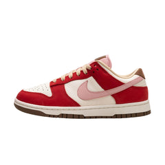 Nike Dunk Low Premium "Bacon" (Women’s) sneakers featuring a unique brown suede upper with light pink and red accents. The classic low-top design includes a white midsole and distinctive branding, displayed against a neutral background to highlight the shoe's playful color scheme and premium materials.



