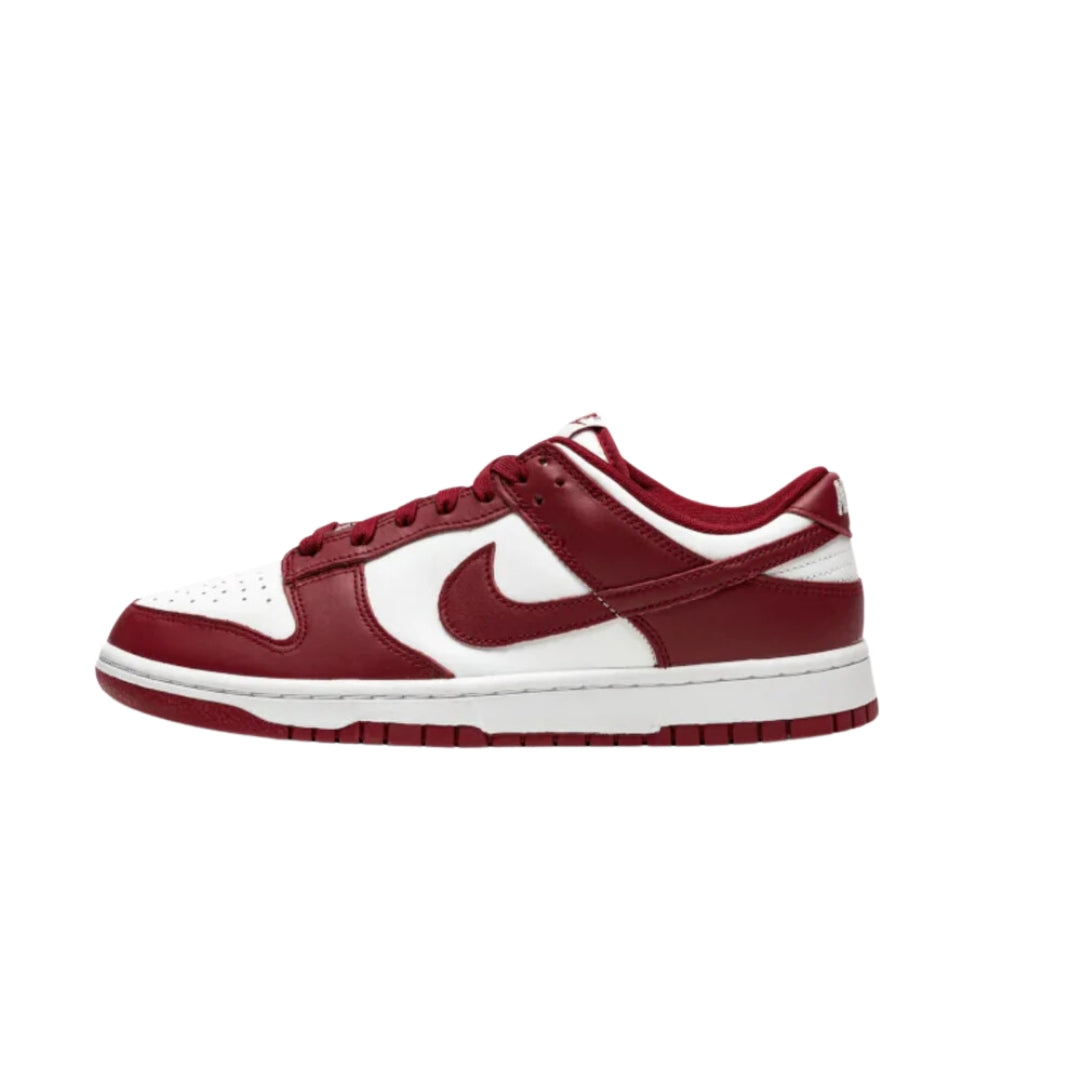 Nike Dunk Low "Team Red" (2022) sneakers featuring a rich red leather upper with white accents. The classic low-top design includes a white midsole and matching laces, showcased against a neutral background to emphasize the shoe's bold colorway and sporty style.



