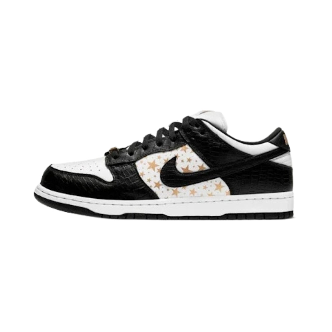 Nike SB Dunk Low Supreme Stars Black is composed of white leather with black fake croc skin overlays and gold stars on the medial section. The Nike SB oversized tongue and croc skin heel patch feature strong Nike branding. The design is completed with a gold metallic Supreme deubré, a white midsole, and a black outsole.